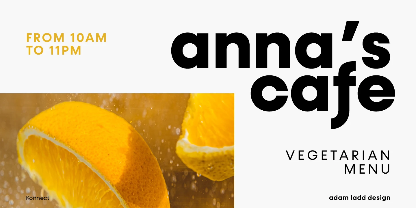 Konnect font by Adam Ladd Design — the words “anna’s cafe” in large, bold, upright sans serif letters, with “FROM 10AM TO 11PM” and “VEGETARIAN MENU” in smaller upright sans serif letters, next to a close-up photo of orange slices in water.
