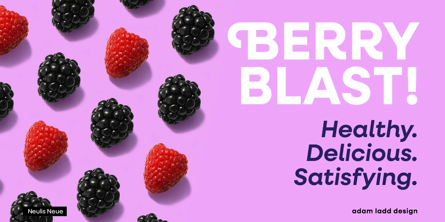 Neulis font by Adam Ladd Design — the words “BERRY BLAST!” in large white sans serif letters, and “Healthy. Delicious. Satisfying.” in smaller dark purple italic sans serif letters, with scattered red raspberries and black blackberries.